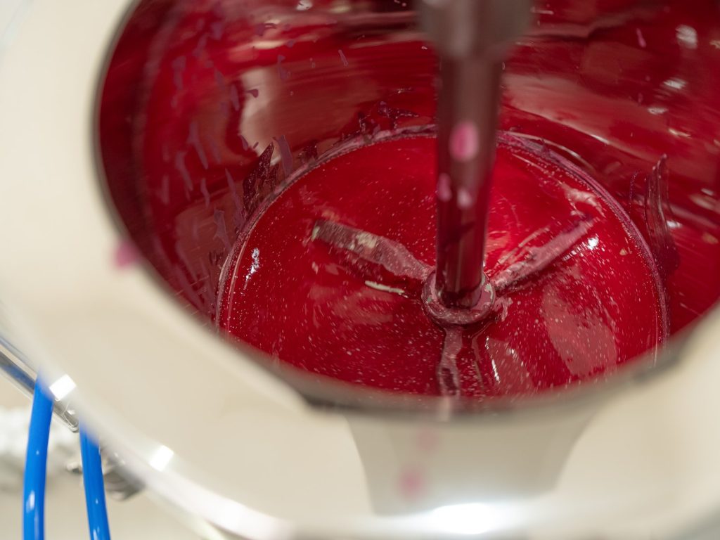 Close-up of red mixing in production — Company Profile, PT Dwi Jaya Cosmedika