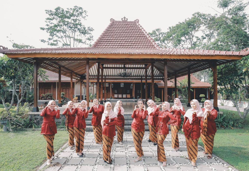 Family members in red kebaya in front of the pendopo — Wedding, Rina & Munir